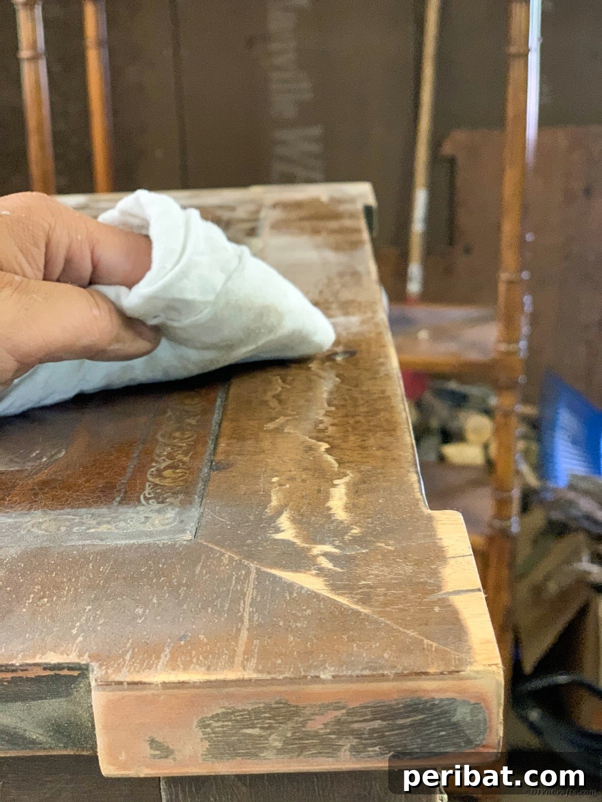 Wiping down the sanded table to remove all dust before painting