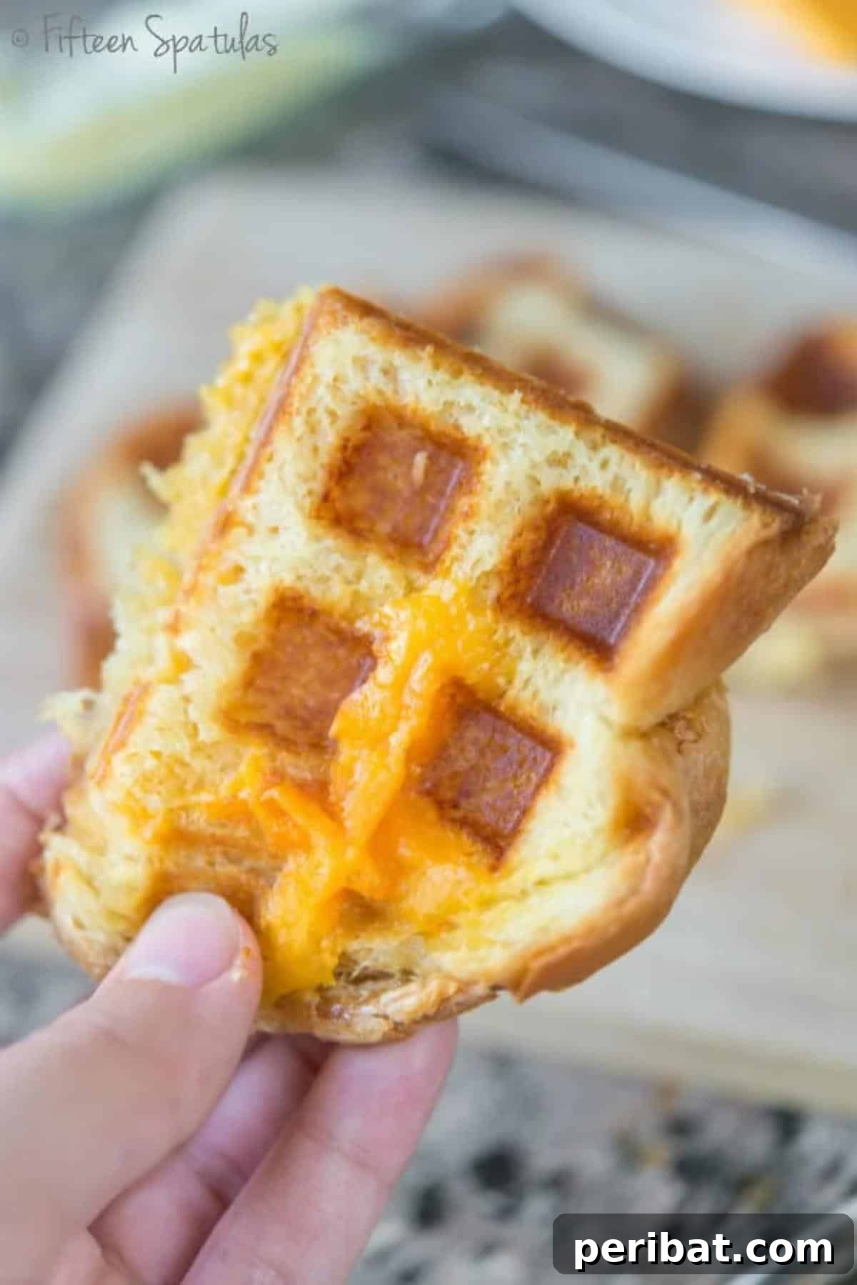 A waffled grilled cheese sandwich, golden brown and crispy, with perfectly melted cheese oozing from the distinct waffle pattern.