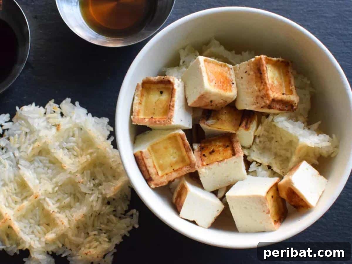 Waffled crispy tofu served alongside miso sesame sticky rice, creating a visually appealing and textured Asian-inspired meal.
