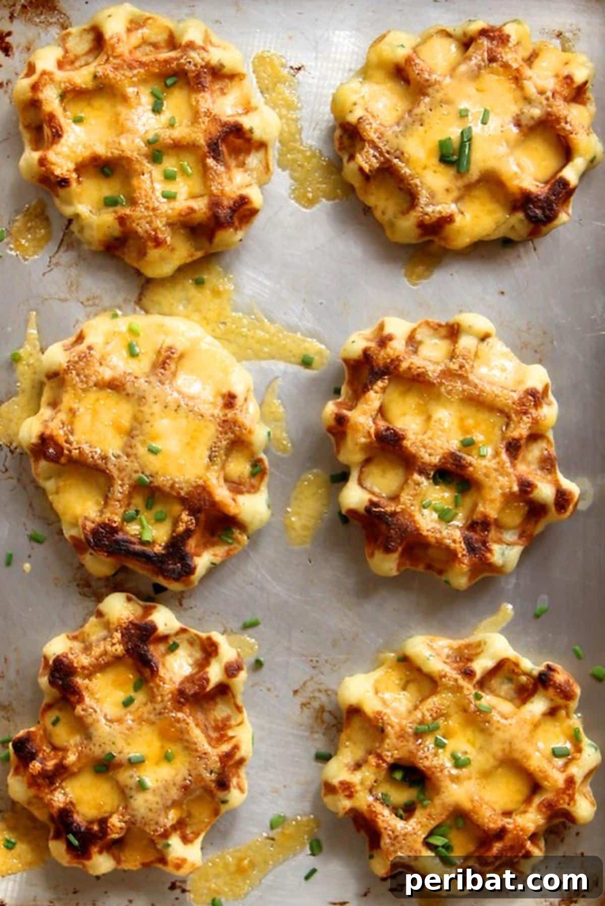 Fluffy mashed potato waffles with melted cheddar cheese and fresh chives, cooked to a crispy golden perfection in a waffle iron.
