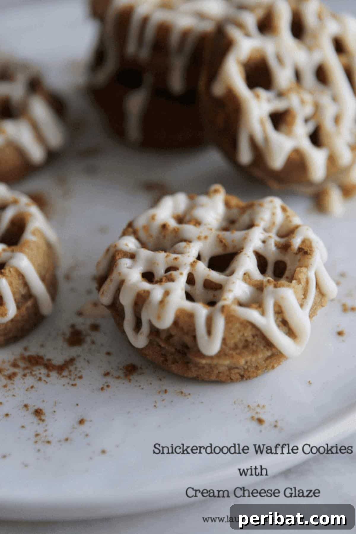 Exquisite snickerdoodle waffle cookies, perfectly round with distinct waffle patterns, generously drizzled with a creamy cream cheese glaze.