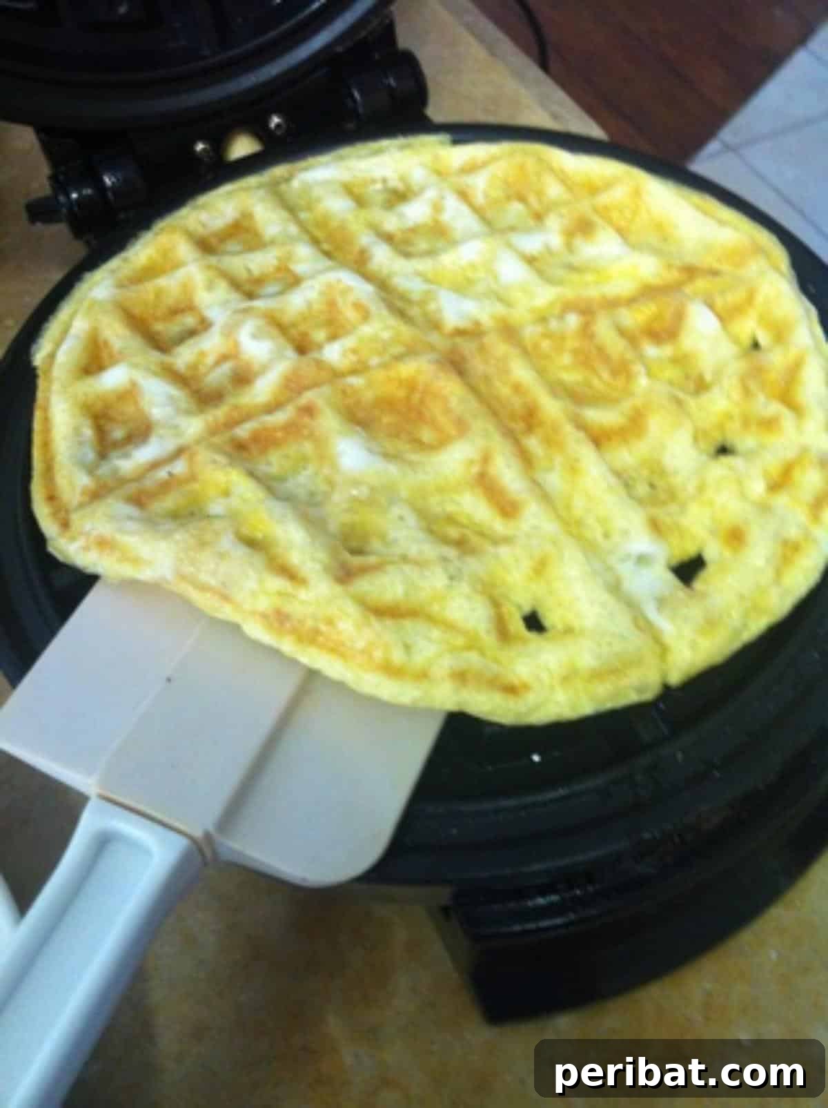 Light and airy scrambled eggs, cooked in a waffle iron, featuring distinct waffle patterns and golden-brown edges.