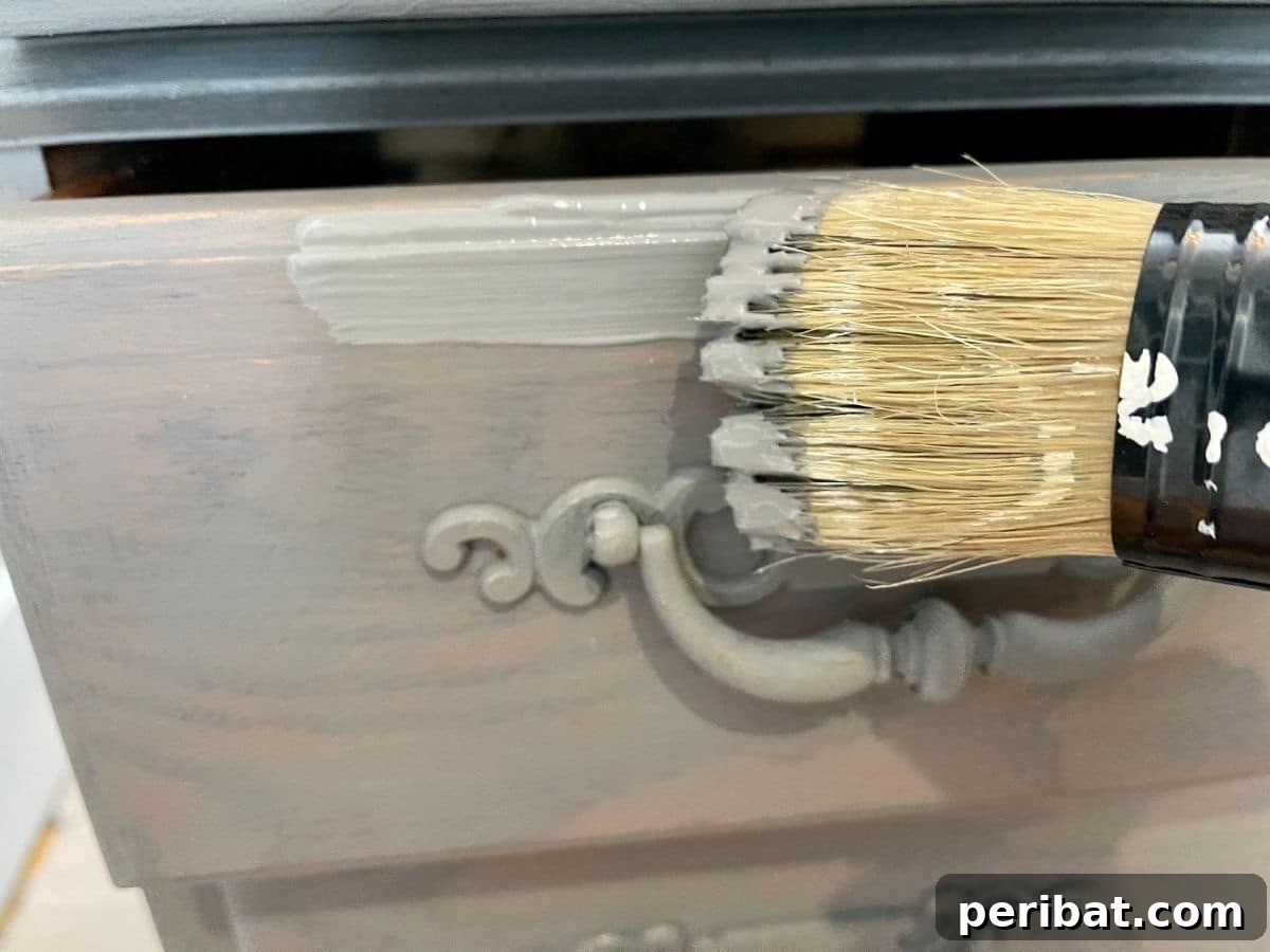 A partially painted desk, showcasing the application of a second layer of paint over the base coat.