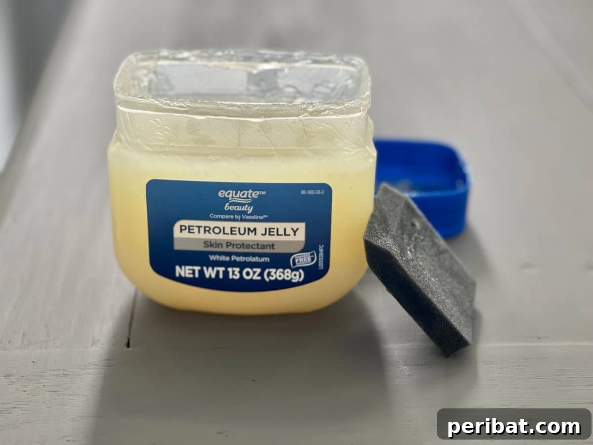 More petroleum jelly is applied to the desk, targeting areas for intentional distressing and paint chipping.