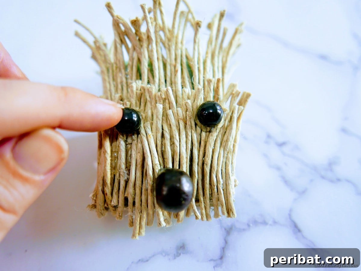 Create a Charming Burlap Hedgehog Decoration 13 Attaching small black beads for eyes and a larger bead for the nose on the hedgehog face