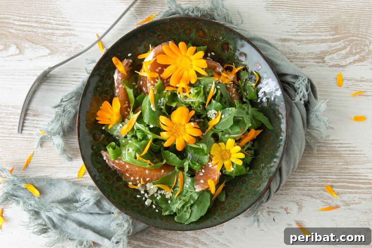 vegetarian flat lay of food with arugula, orange, sesame seeds and edible marigold flowers in the table
