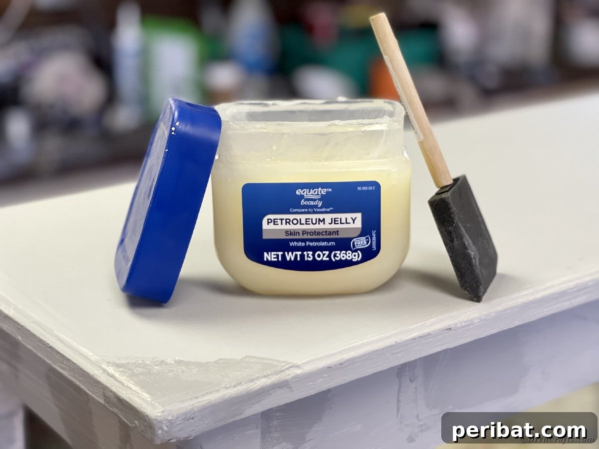 Applying petroleum jelly to furniture edges with a foam brush for a distressed effect