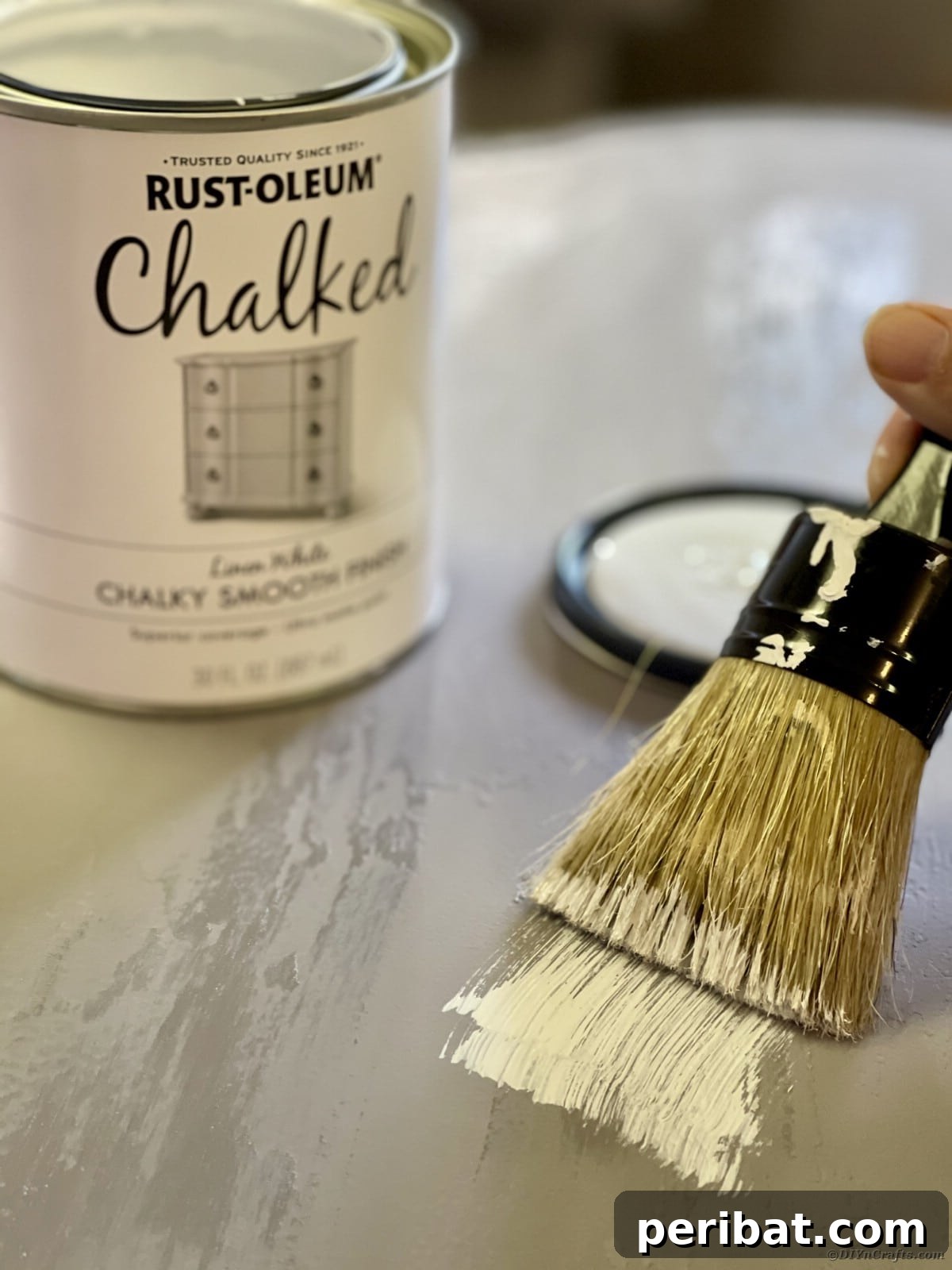 Chippy Charm Side Table Transformation 12 Paintbrush with white paint going over top of grey table