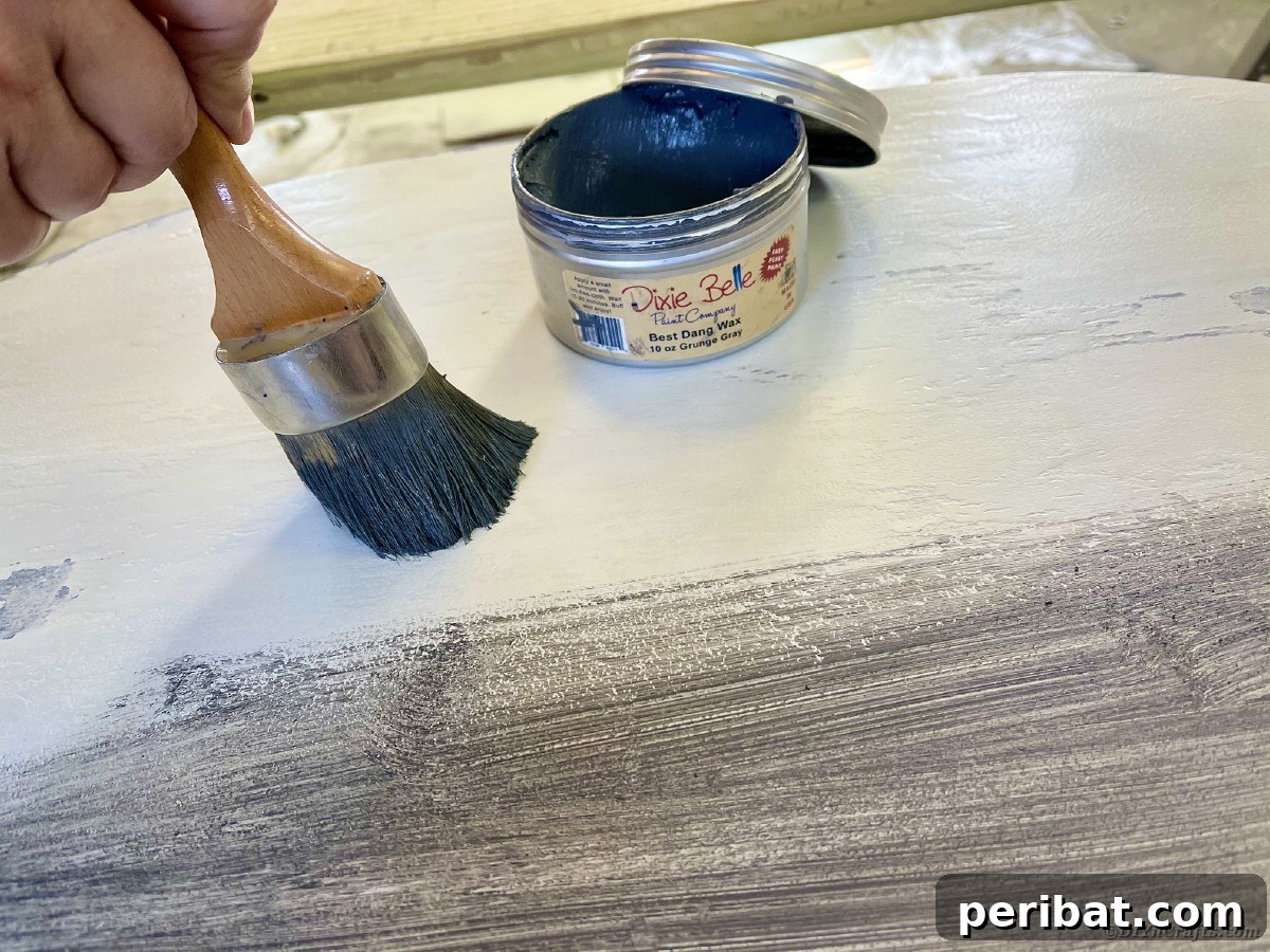 Chippy Charm Side Table Transformation 15 Dark paint brush wiping wax onto top of table