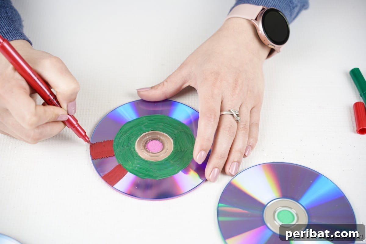 Sparkling Repurposed Garden Melody 12 A hand painting a CD with bold red stripes, creating a striking and colorful pattern.
