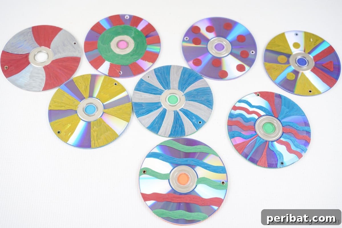 Sparkling Repurposed Garden Melody 14 A collection of vibrant, hand-painted CDs arranged on a white table, showcasing diverse designs.