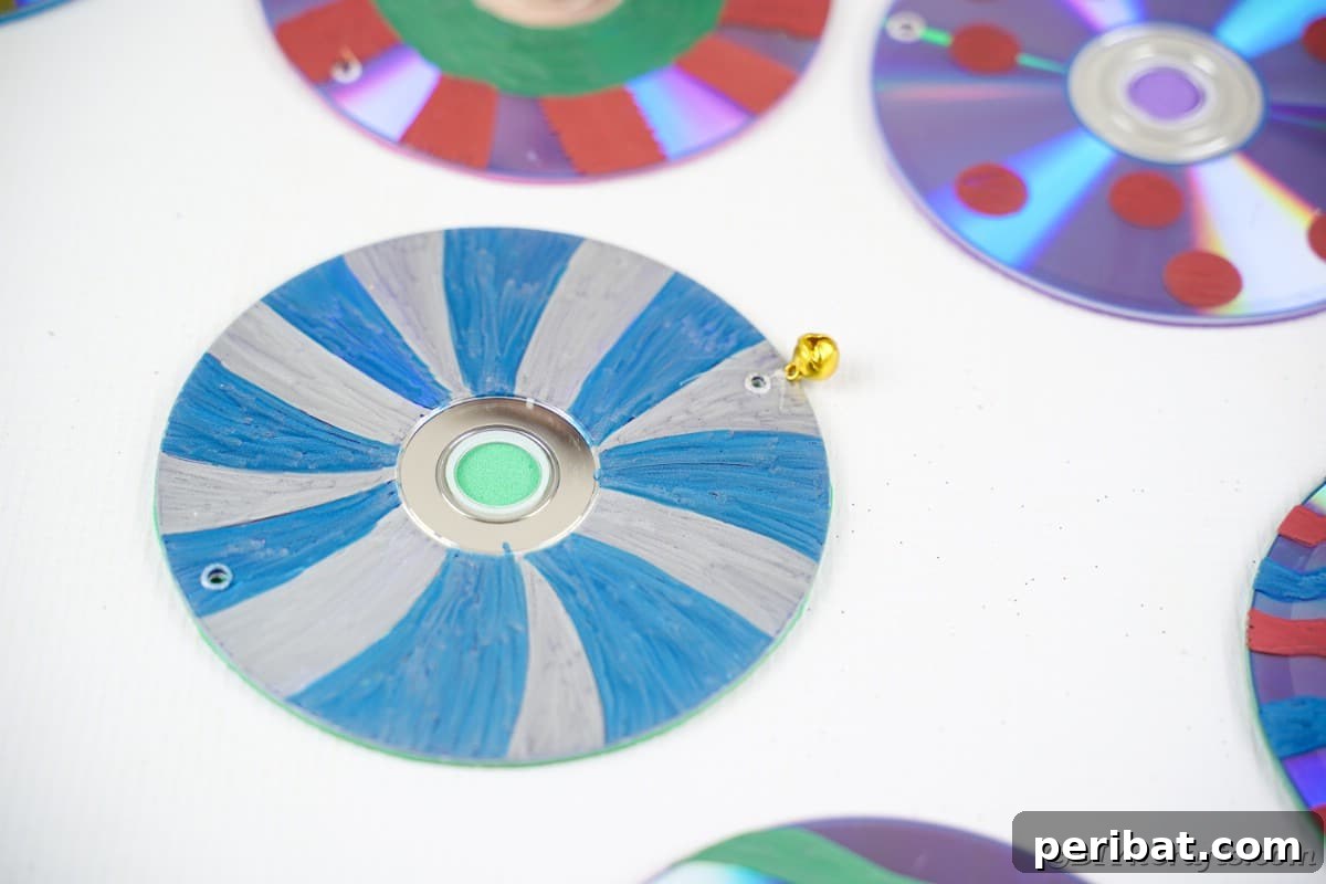 Sparkling Repurposed Garden Melody 16 Close-up of several colorful CDs, each with a small bell attached to its bottom edge.