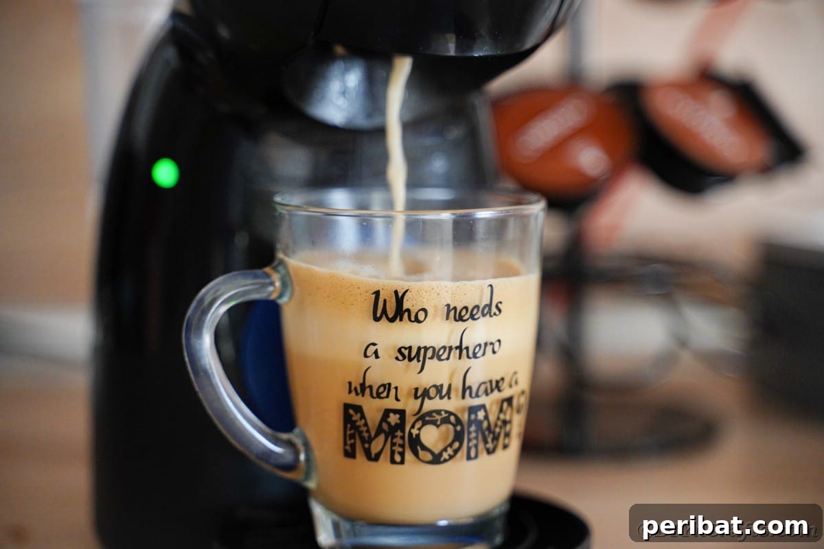 A clear glass mug being filled with freshly brewed coffee, highlighting the potential for personalized drinkware.