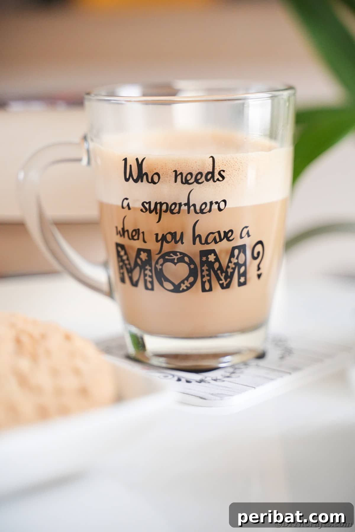 Glass mug with 'Superhero Mom' in black vinyl next to cookies