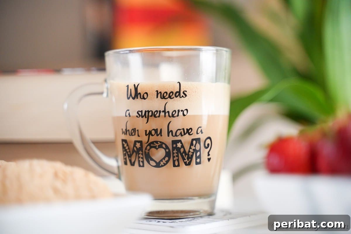 A glass mug with a 'Superhero Mom' message sits next to a tray of cookies, highlighting the heartfelt design.