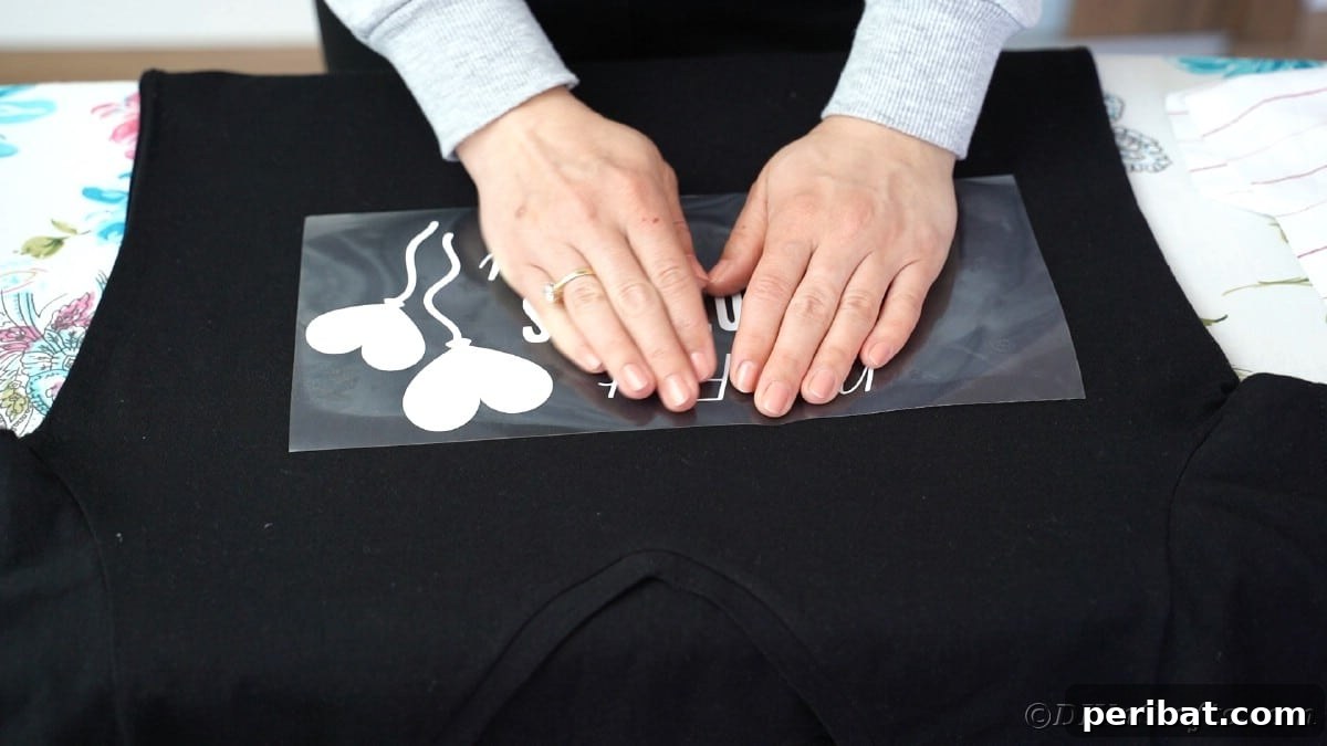Pressing vinyl onto a black t-shirt with hands