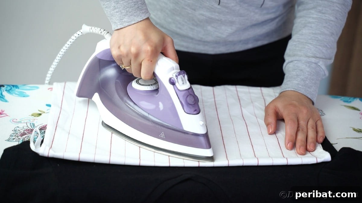 Ironing vinyl onto a black t-shirt with steady pressure