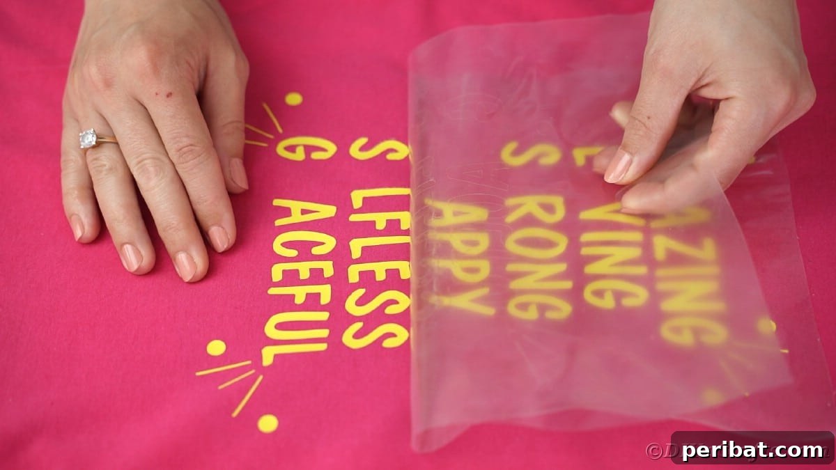 Placing yellow vinyl letters onto a pink t-shirt for the 'Amazing Mom' design