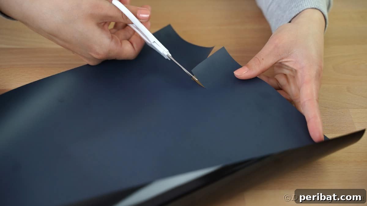 Cutting black vinyl letters for the 'Mom' part of the design