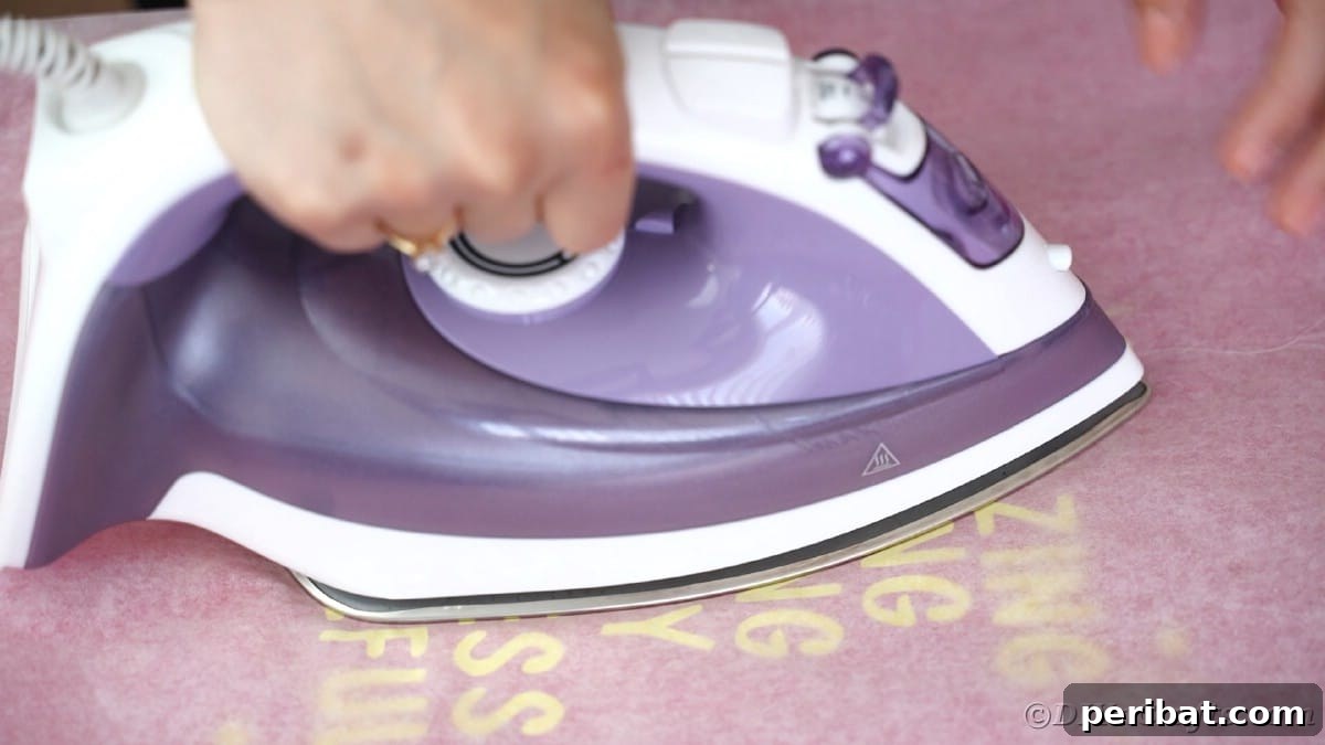 Ironing over wax paper to seal vinyl onto the t-shirt