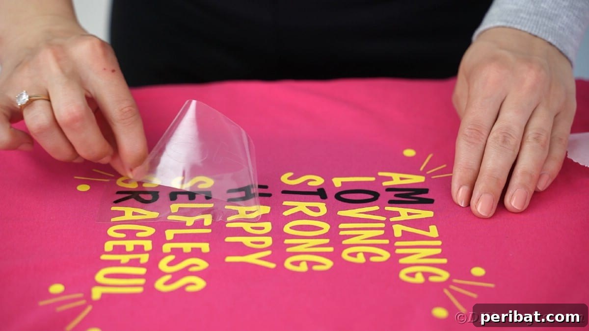 Peeling carrier sheet off black letters on a custom t-shirt