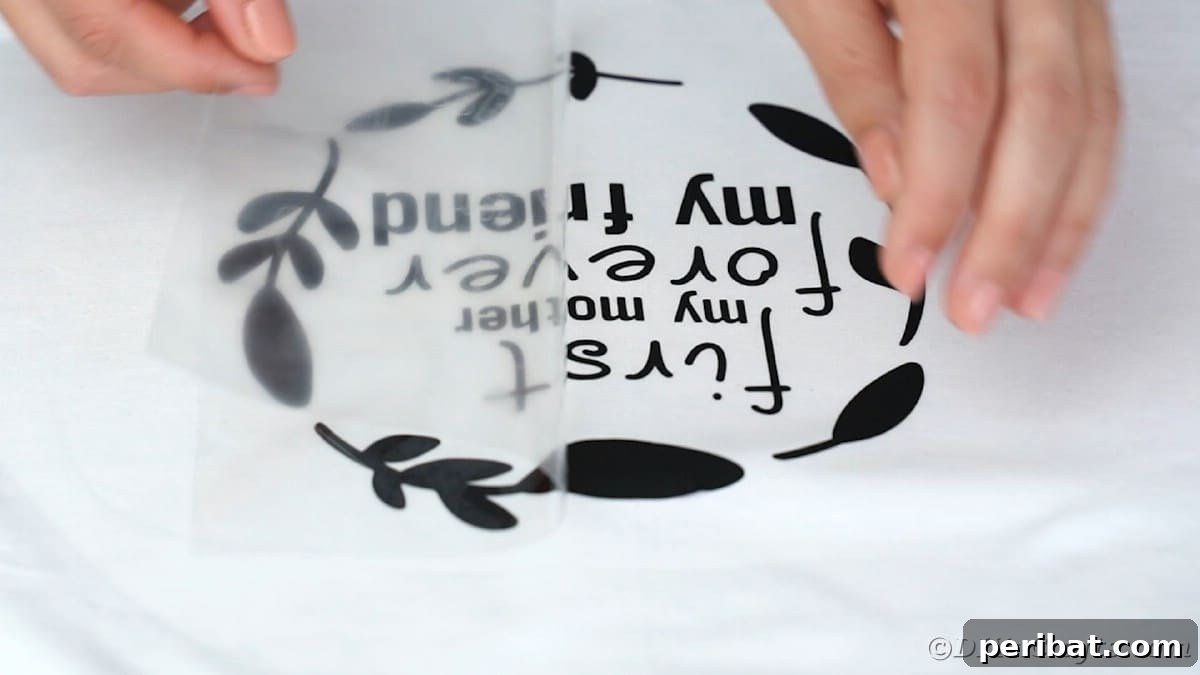 Peeling sheet off the top of vinyl on a t-shirt