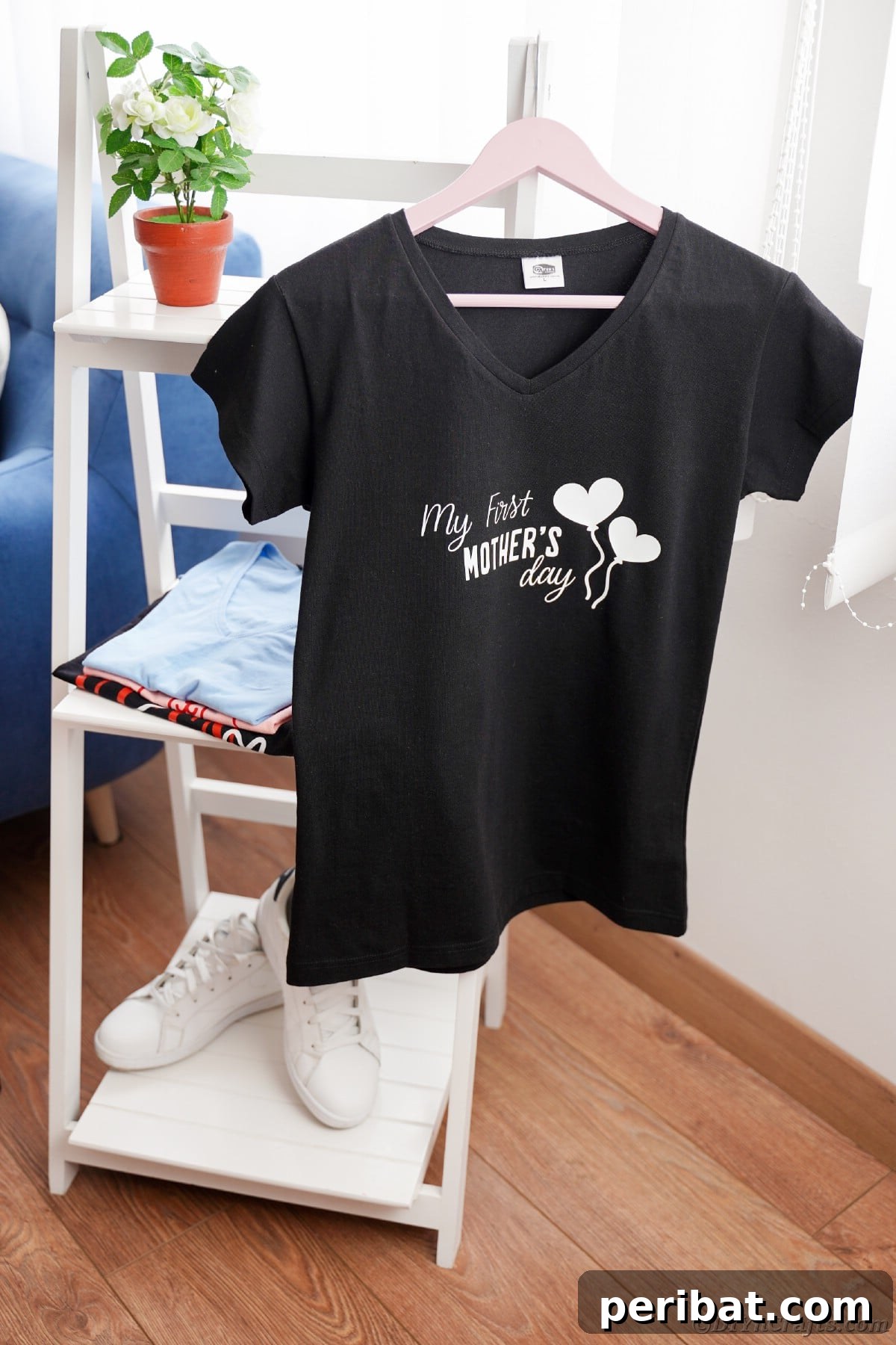 Black custom Mother's Day t-shirt hanging on a white shelf