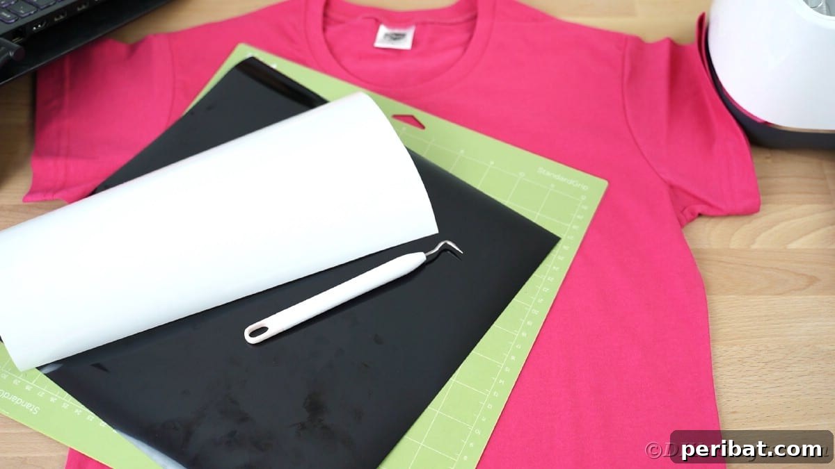 Pink custom t-shirt with Cricut mat and vinyl on top