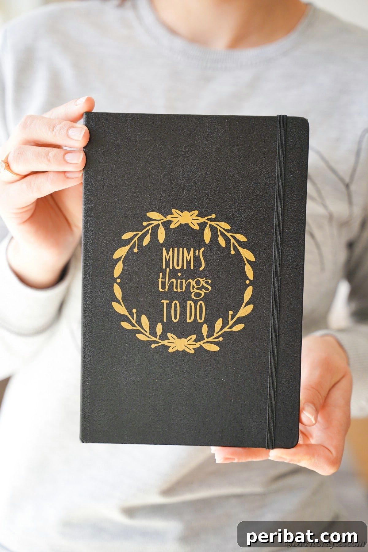 Craft Personalized Vinyl Journals for Mother's Day 15 Woman holding black book with gold lettering on cover