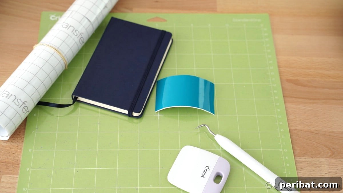 Craft Personalized Vinyl Journals for Mother's Day 10 Green cricut mat on table with roll of paper and blue book on top