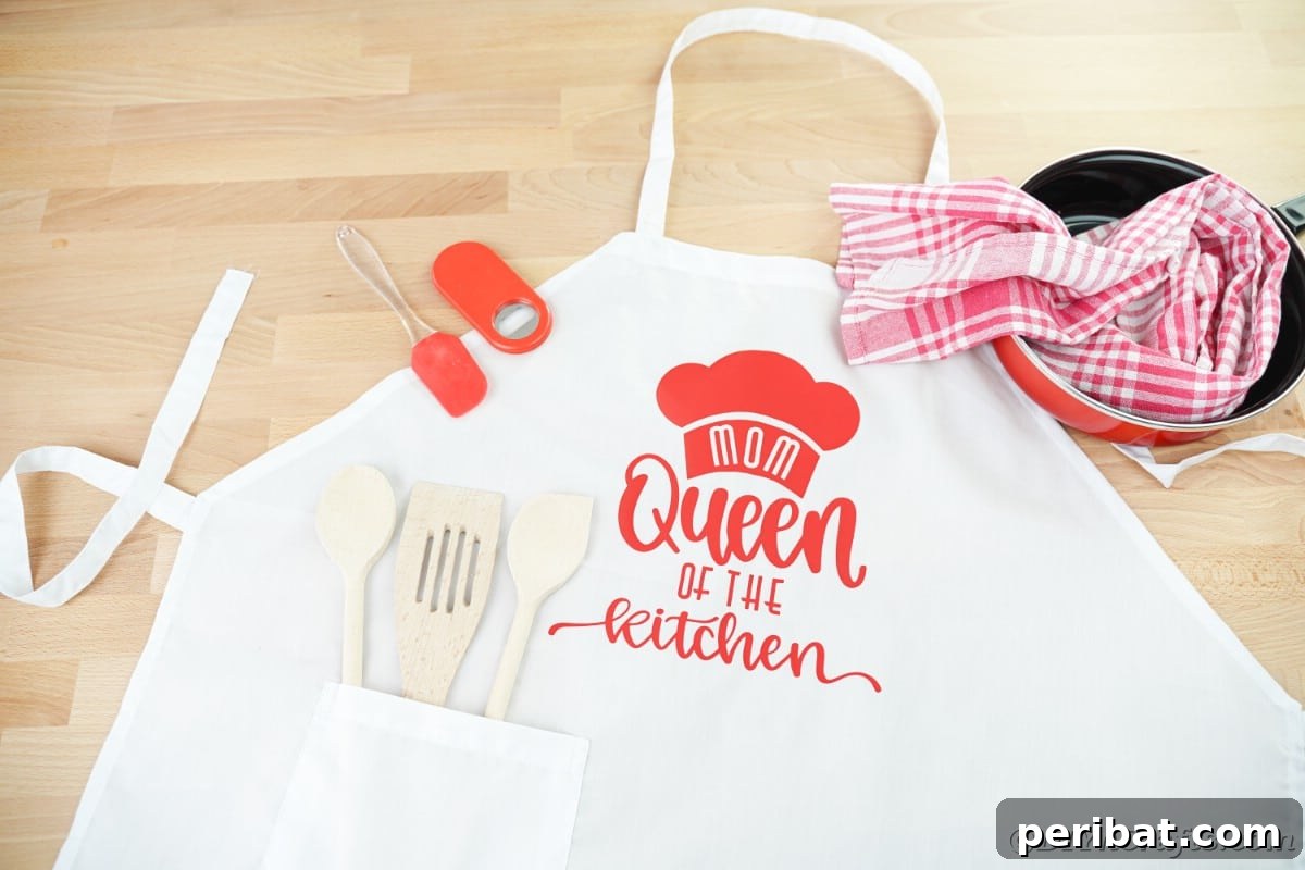A close-up of a white apron featuring a bold red Cricut vinyl message, highlighting the crisp detail and successful application of the design.