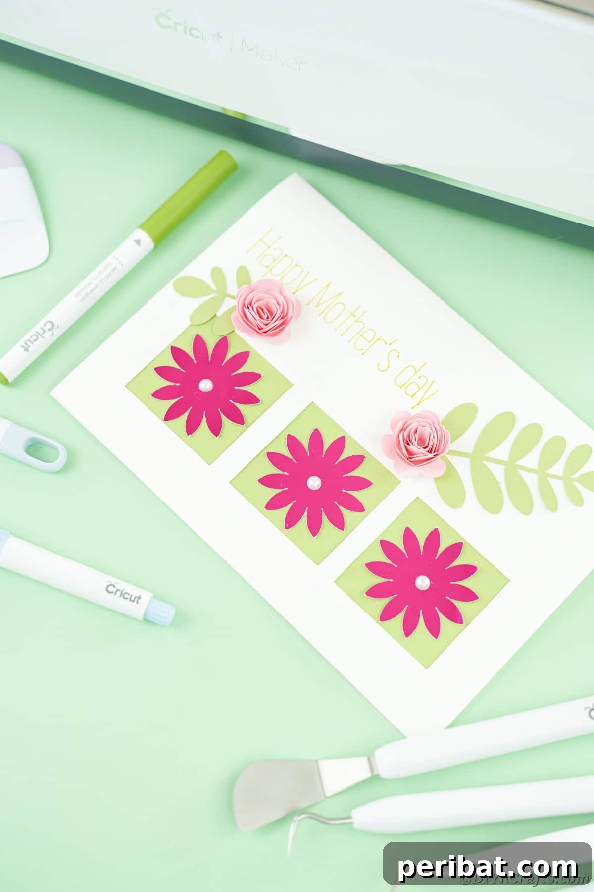 White card with pink flowers on green table by cricut tools