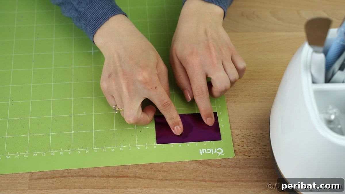 Placing purple vinyl on green Cricut mat, ensuring smooth application