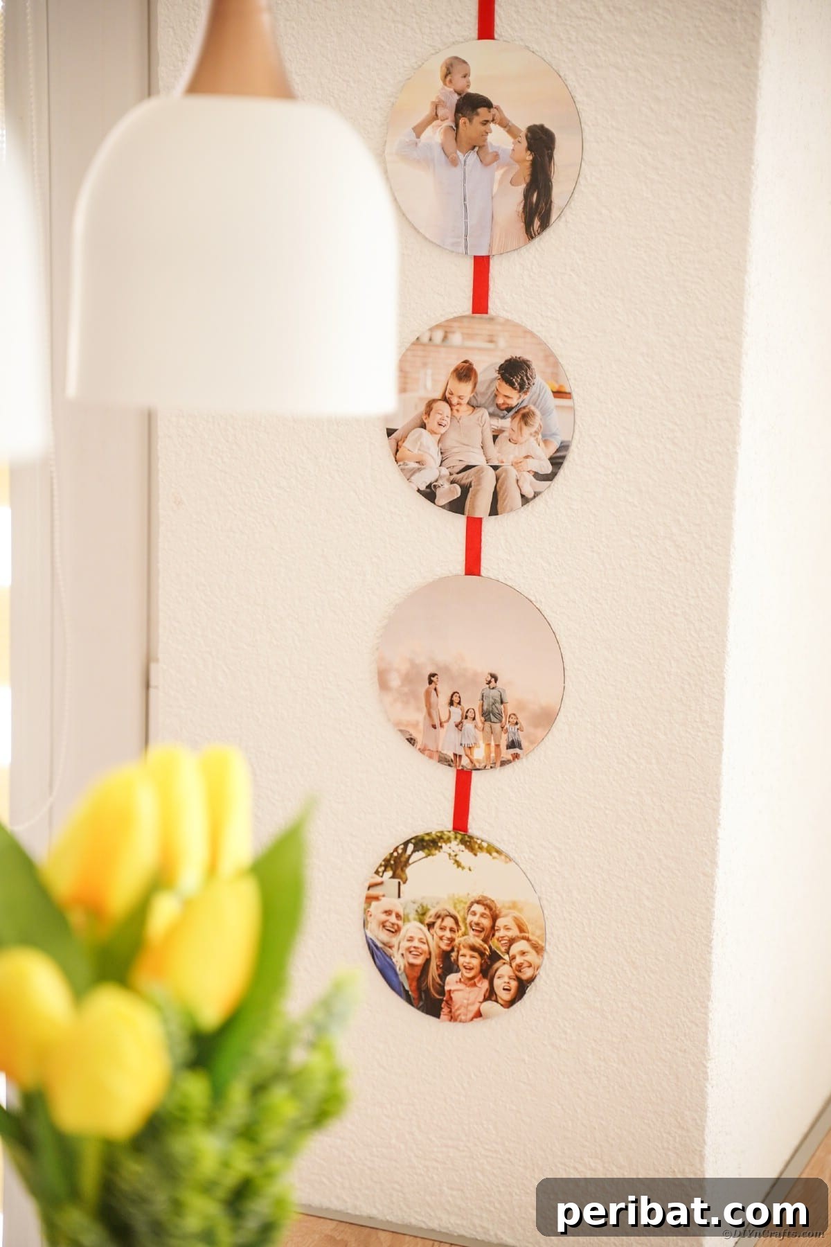 A cozy living room scene featuring a white wall adorned with a beautiful red ribbon photo holder, strategically placed behind a soft lamp, creating a warm ambiance.