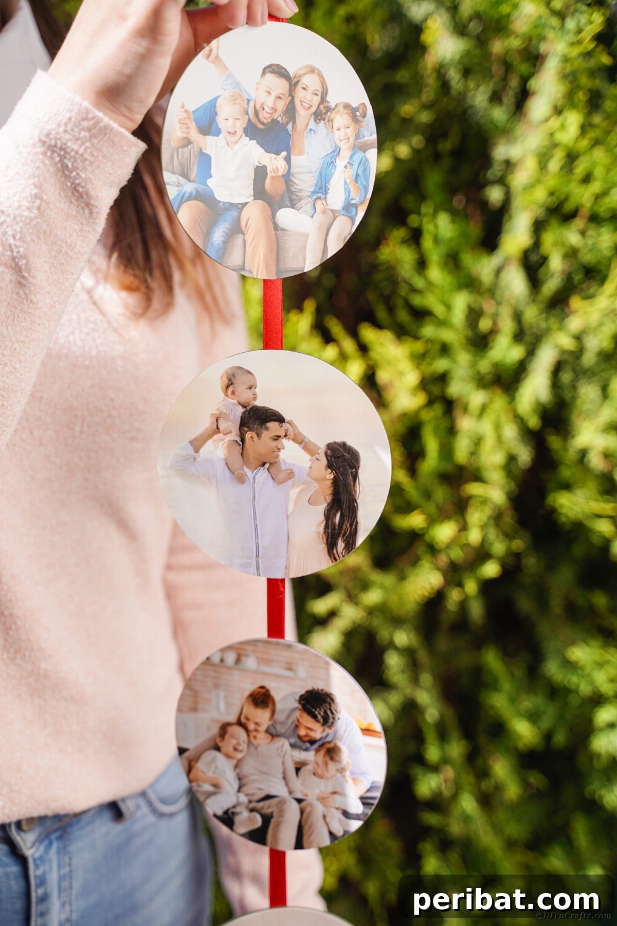 Creative CD Upcycle: DIY Photo Garland for Memories 9 A woman's hands gently holding a completed photo ribbon, strung with various pictures, symbolizing cherished memories and handmade craftsmanship.
