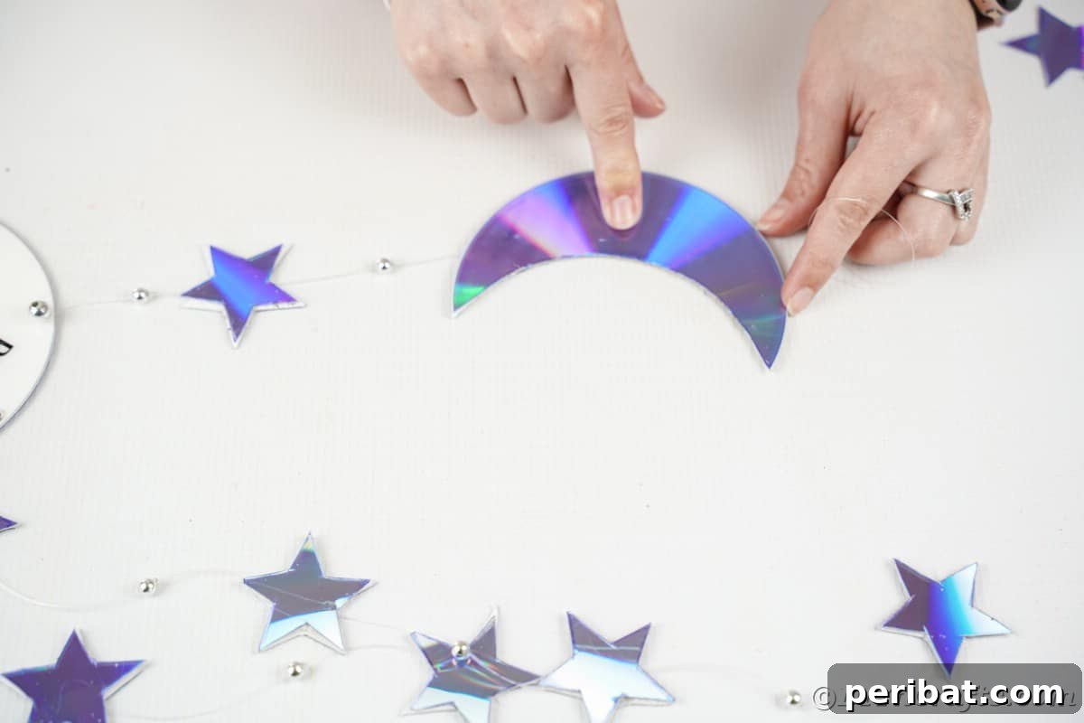 Celestial Sparkle DIY Upcycled CD Moon and Stars Baby Mobile 20 Adding moon onto fishing line