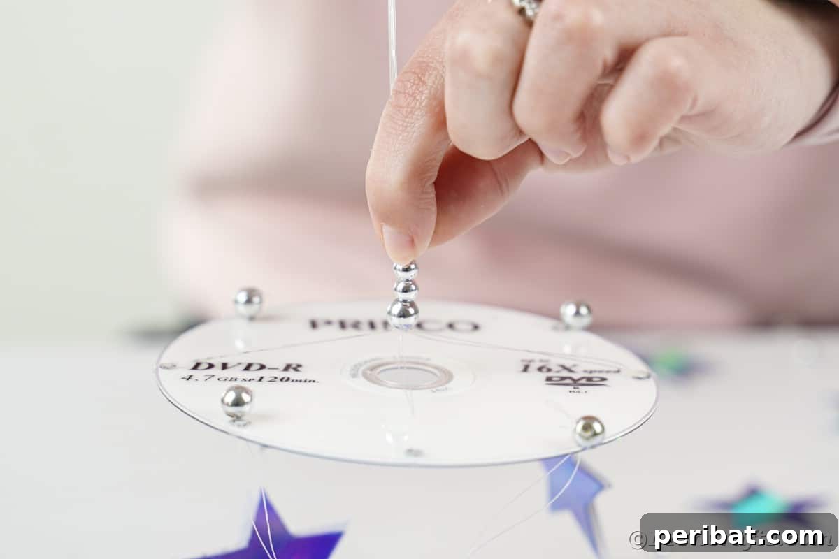 Celestial Sparkle DIY Upcycled CD Moon and Stars Baby Mobile 22 Decorating mobile with beads.
