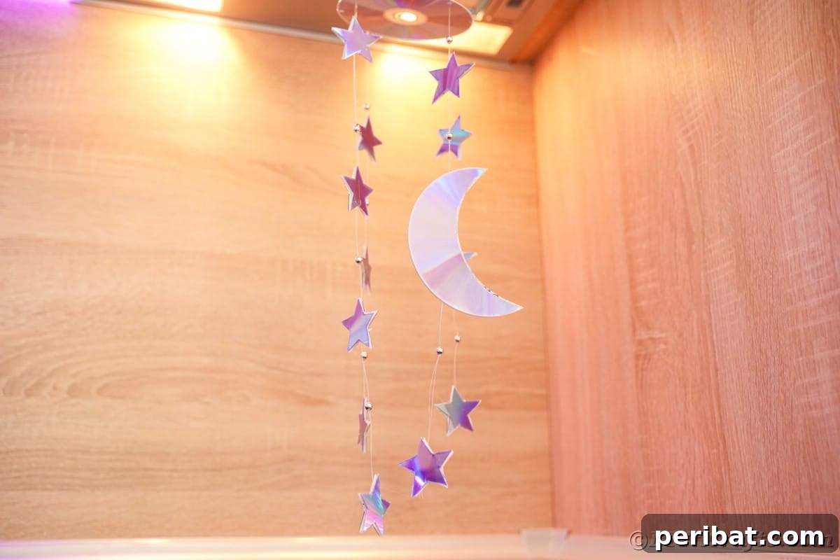 Celestial Sparkle DIY Upcycled CD Moon and Stars Baby Mobile 4 Stars and moon mobile hanging under light in kitchen