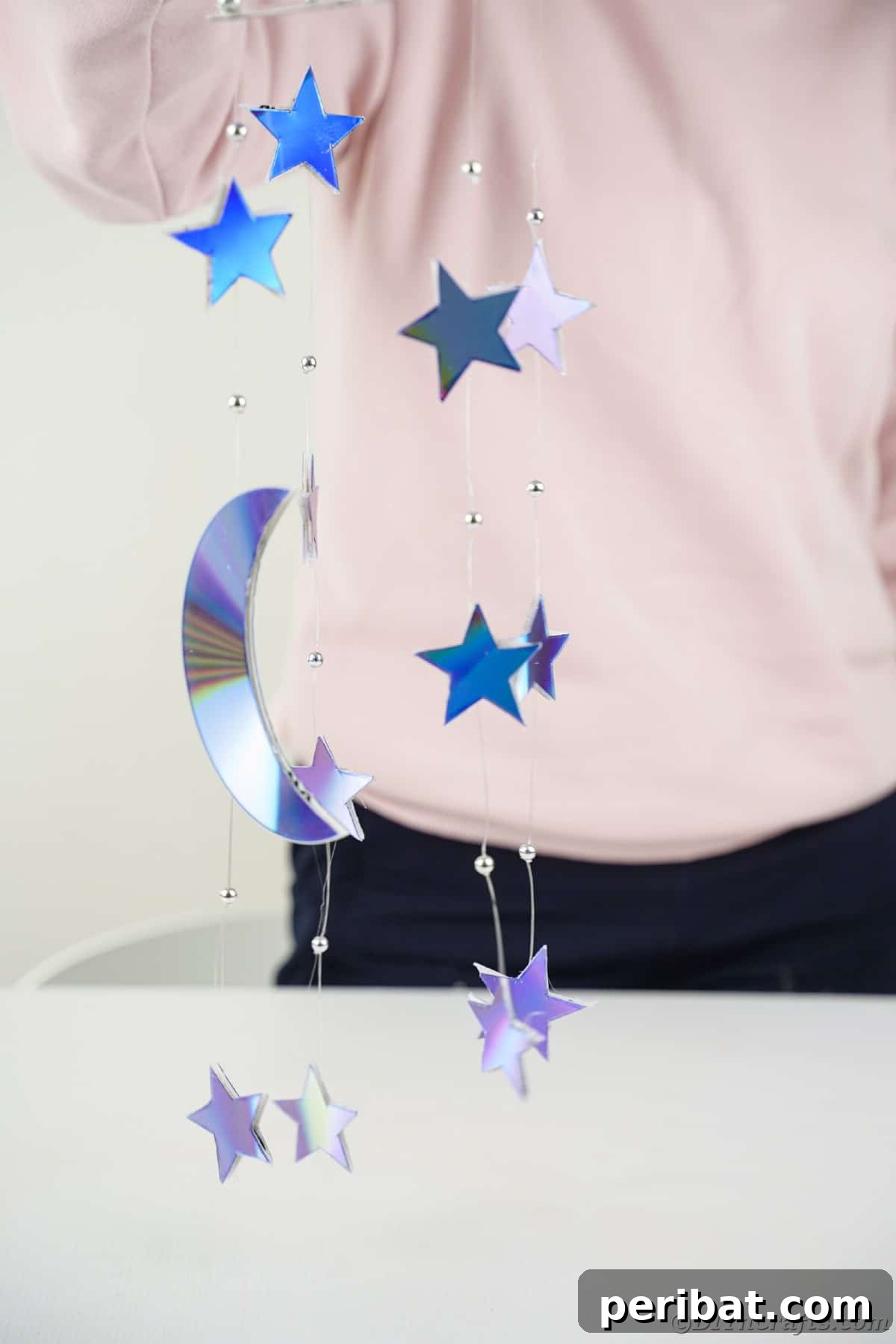Celestial Sparkle DIY Upcycled CD Moon and Stars Baby Mobile 8 Woman in pink holding up mobile