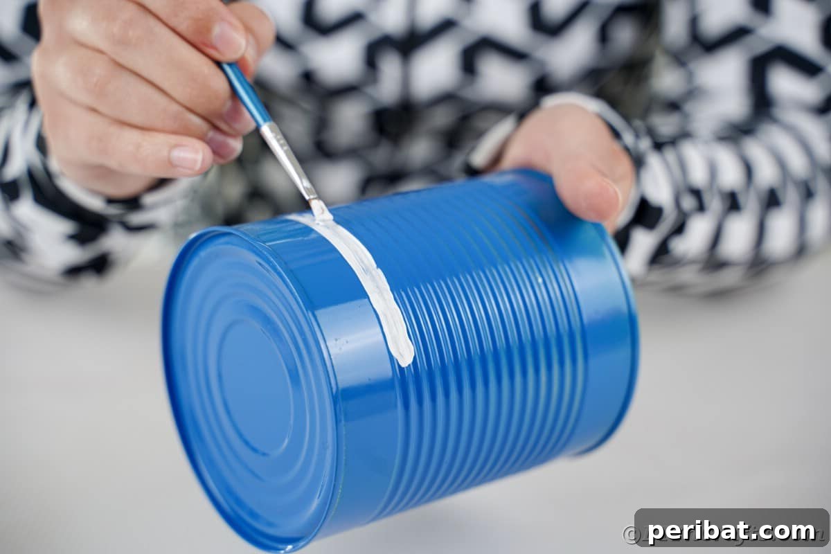 Painting a white strip on blue tin can