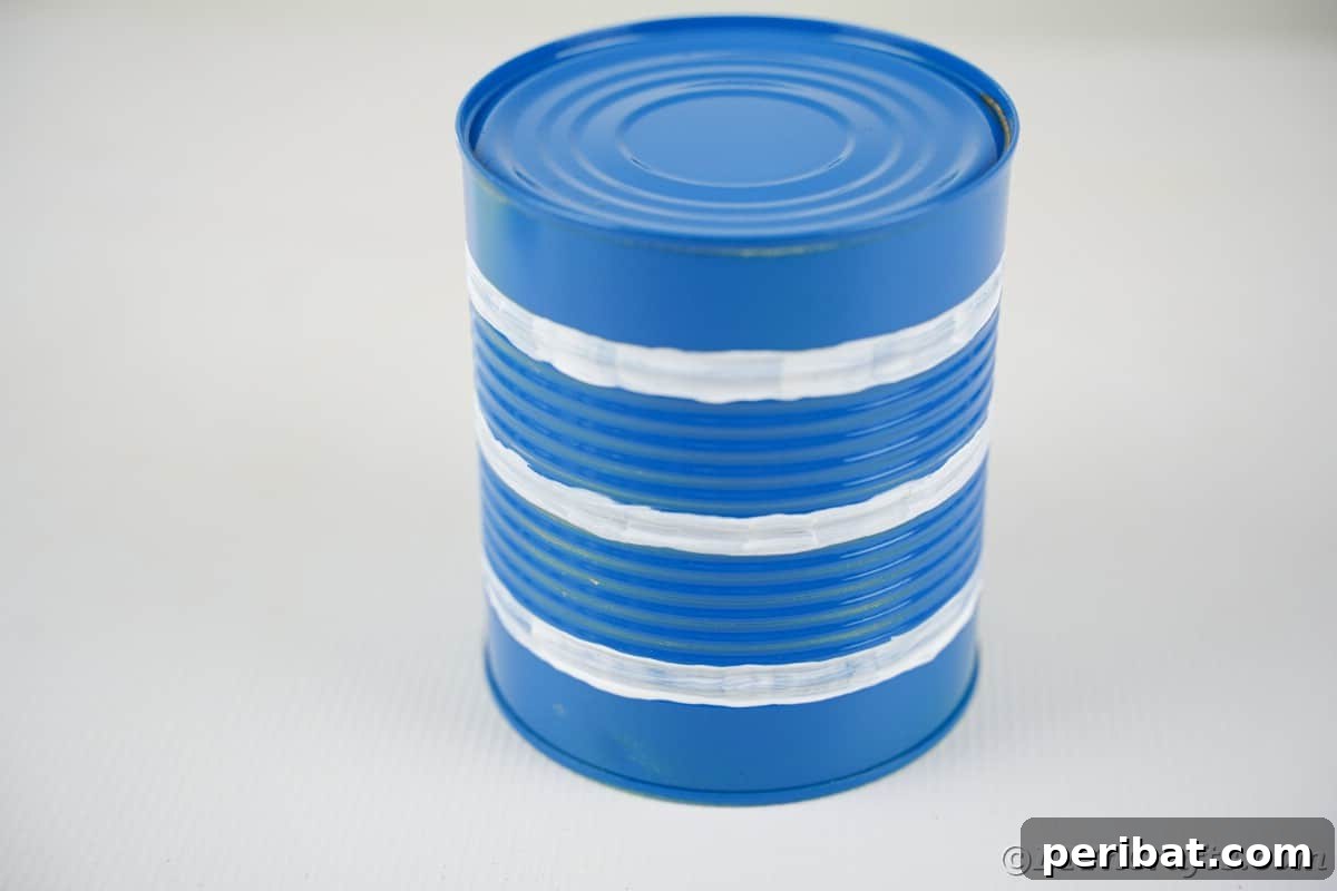 Blue tin can with white stripes painted around it