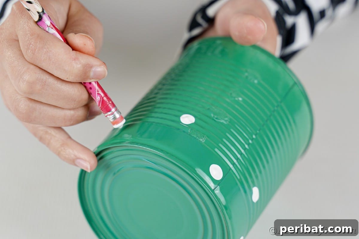Painting white dots on green tin can