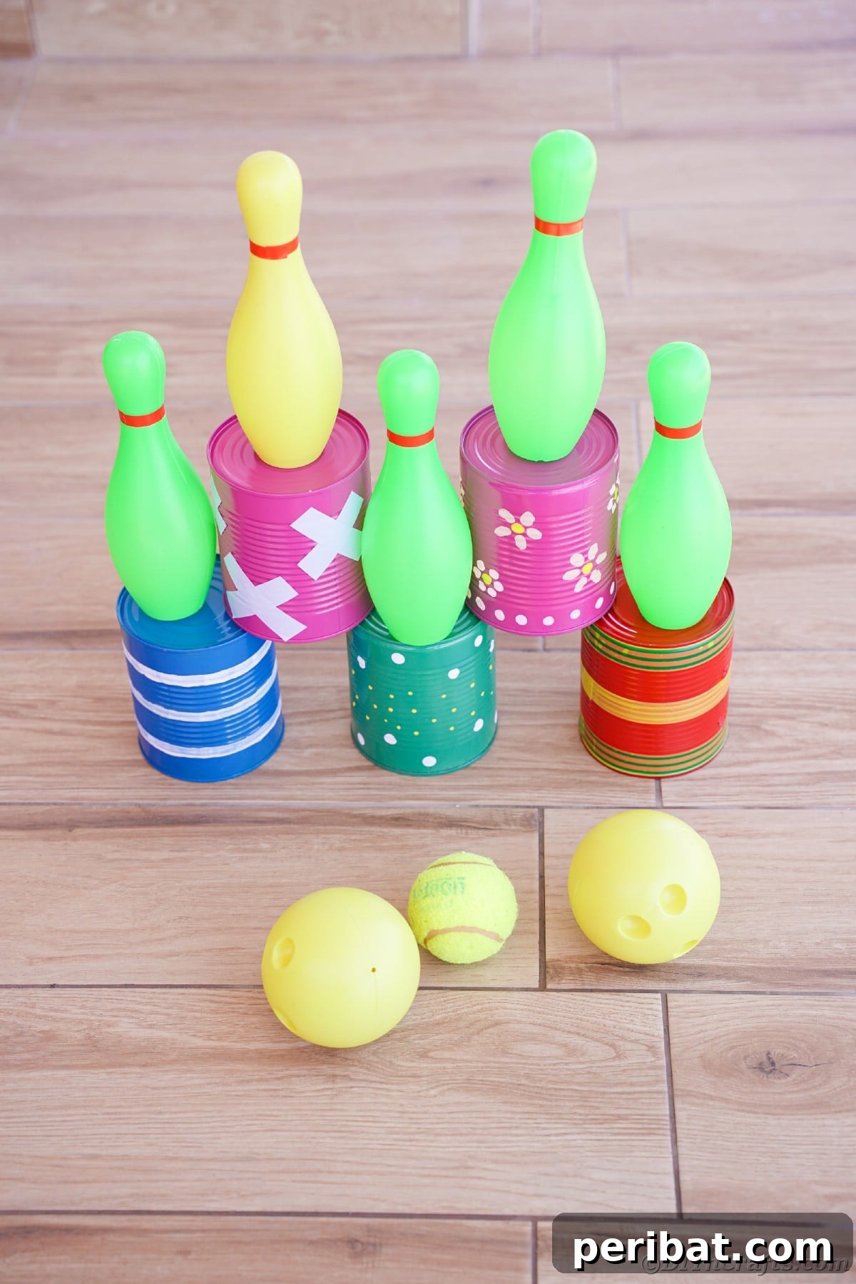 Tin cans with mini bowling pins on top and balls in front