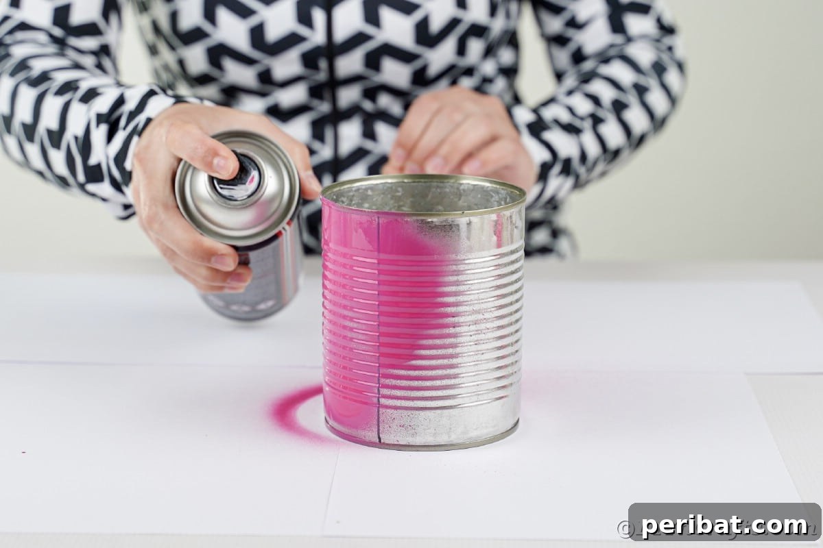 Spray painting a tin can pink