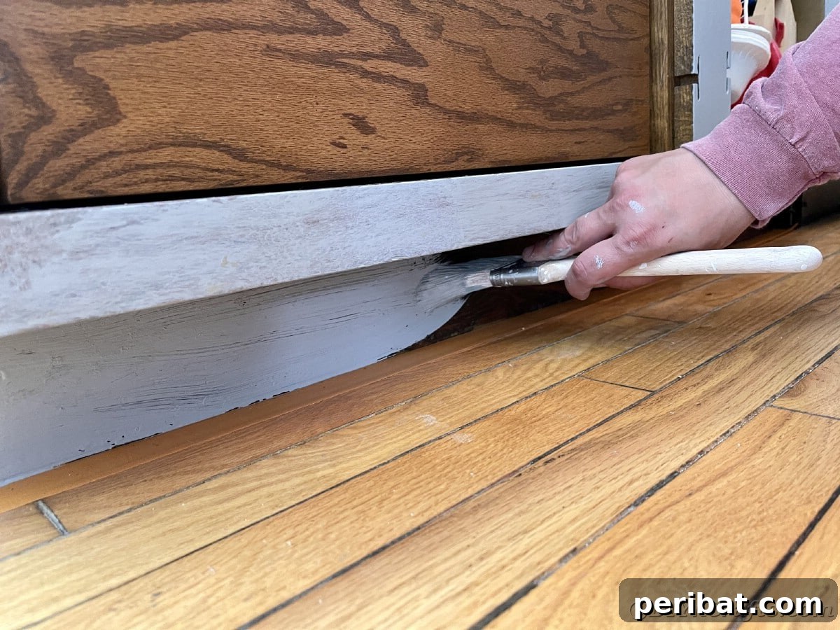 Painting floorboards with primer, ensuring a uniform base for the final paint coat