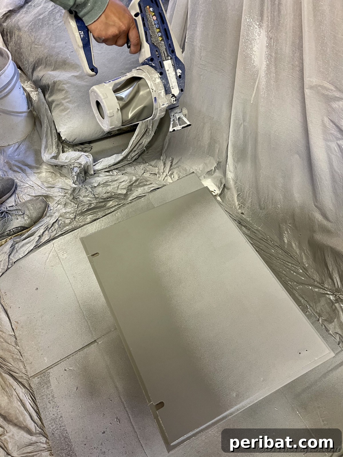 A freshly painted cabinet door lying flat, showcasing the smooth, even primer coat