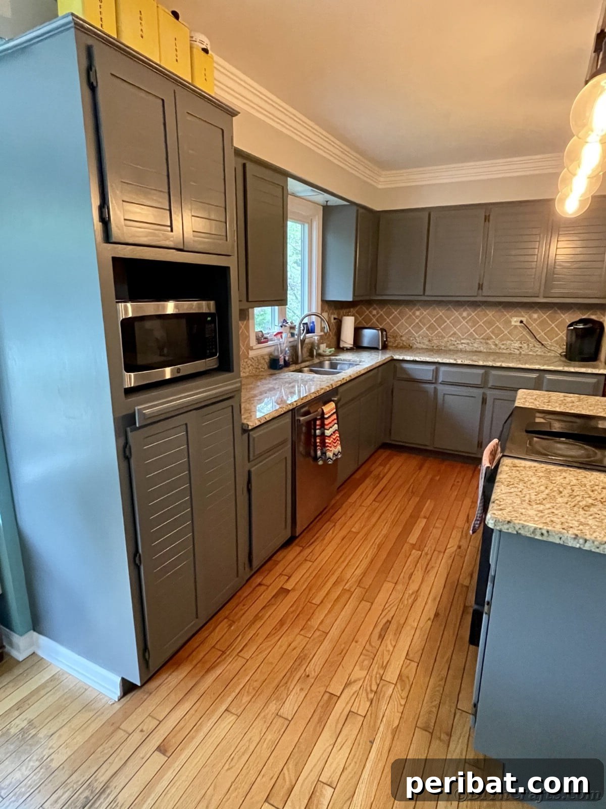 Kitchen featuring sophisticated gray cabinets, gleaming marbled countertops, and contemporary design