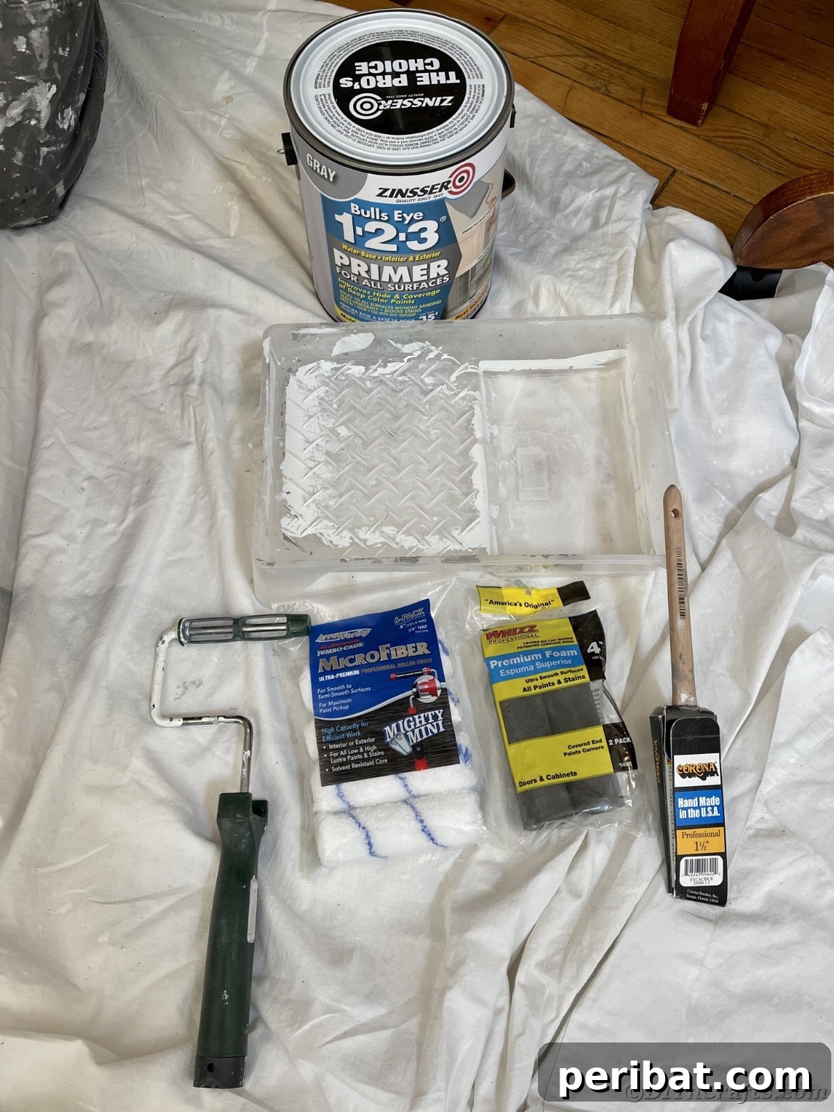 Supplies neatly arranged on a protective drop cloth, ready for kitchen cabinet painting