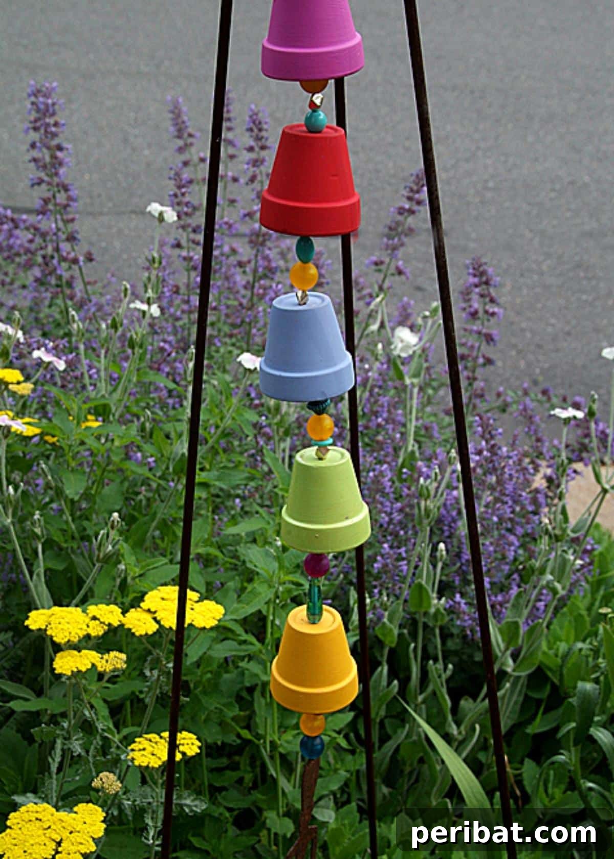 27 Terracotta Crafts to Elevate Your Outdoor Decor 27 DIY Bell Tower Chime, a colorful wind chime made from small terra cotta pots and beads.