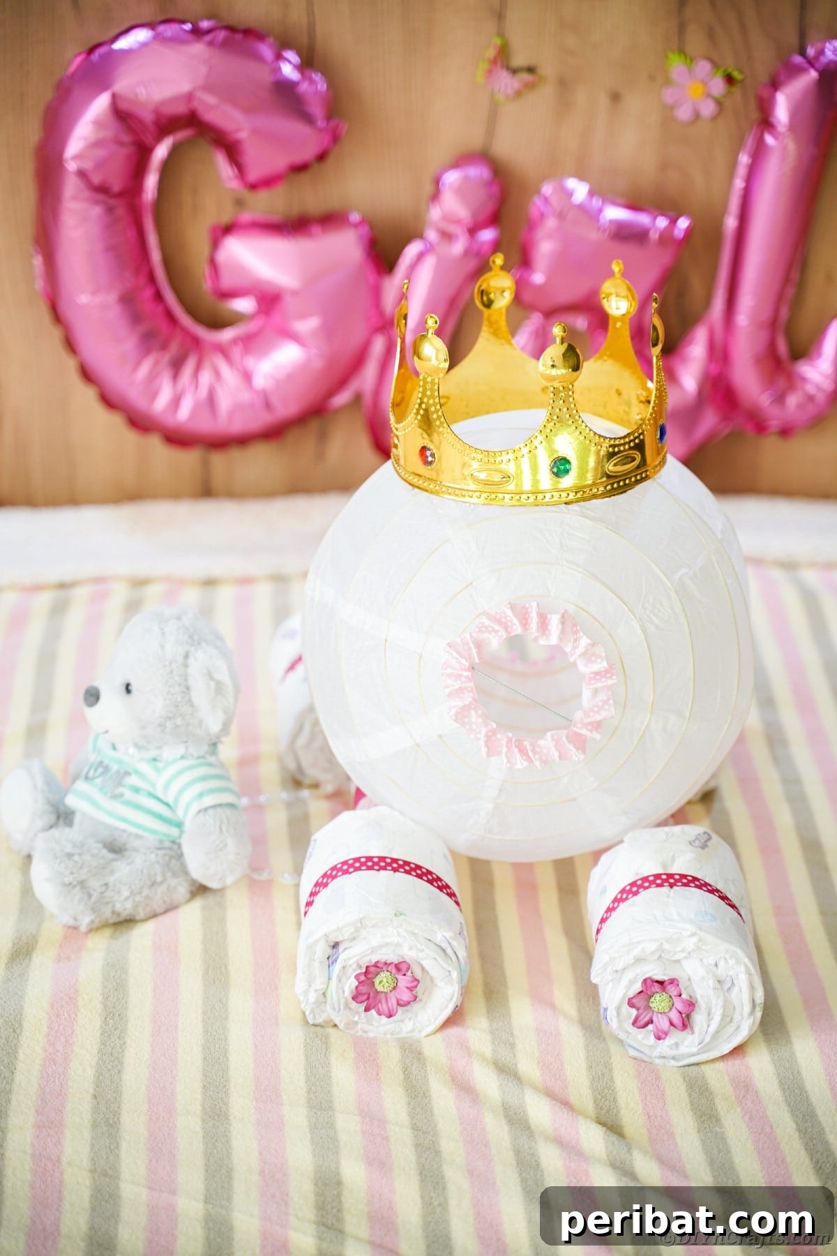 Enchanting Diaper Carriage Baby Shower Surprise 3 Carriage diaper cake on striped bedding with girl balloon in background